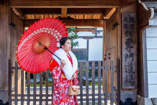 Asiatische Frauen, die japanischen traditionellen Kimono tragen, der das schöne in Kyoto besucht.
