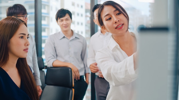 Asiatische geschäftsleute und geschäftsfrauen treffen sich mit brainstorming-ideen, um gemeinsam kollegen des geschäftspräsentationsprojekts zu planen und die erfolgsstrategie zu planen.