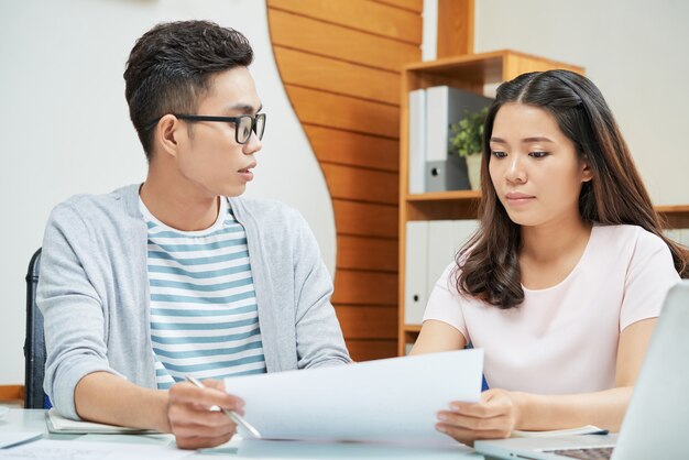 Asiatische junge Kollegen, die mit Papieren arbeiten