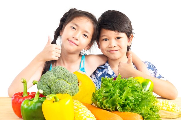 Asiatische Jungen- und Mädchenvertretung genießen Ausdruck mit frischem buntem Gemüse