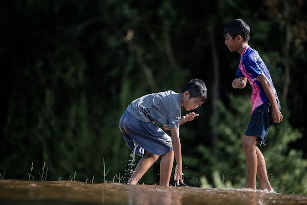 Kostenloses Foto asiatische kinder, die in einem fluss spielen