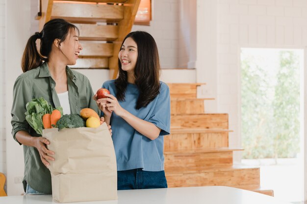 Asiatische lesbische lgbtq Frauenpaare halten Einkaufpapiertüten zu Hause