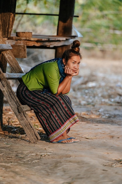 Kostenloses Foto asiatische schöne frau, die auf einer holztreppe und einem kinn auf der hand sitzt, sie freut sich mit fühlt sich einsam, kopiert raum, rarul lifestyle-konzept