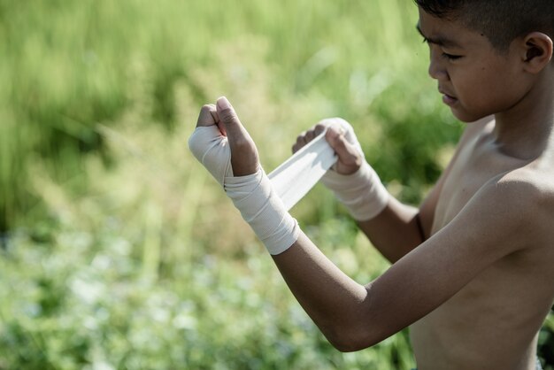 Asiatischer Boxer des kleinen Jungen mit Natur