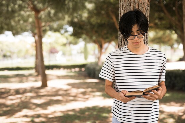 Asiatischer Jugendstudent mit geöffnetem Buch