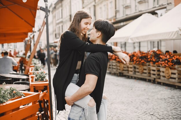 Asiatischer Junge und seine kaukasische Freundin in Freizeitkleidung stehen auf der Lviv-Straße. Paar umarmt sich beim gemeinsamen Spaziergang in der Stadt