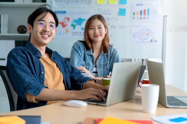 Asiatischer Kollege, männliche und weibliche Freundin, Freizeitkleidung, Treffen, Beratung, Zusammenarbeit mit Spaß und Glück am Arbeitsplatz, Geschäftspartner, Beziehungsideenkonzept