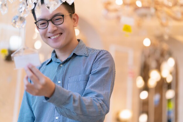 Asiatischer Kunde Smart Male Wear Shirt Glück beim Einkaufen im Kaufhaus Geschäftsideen Konzept
