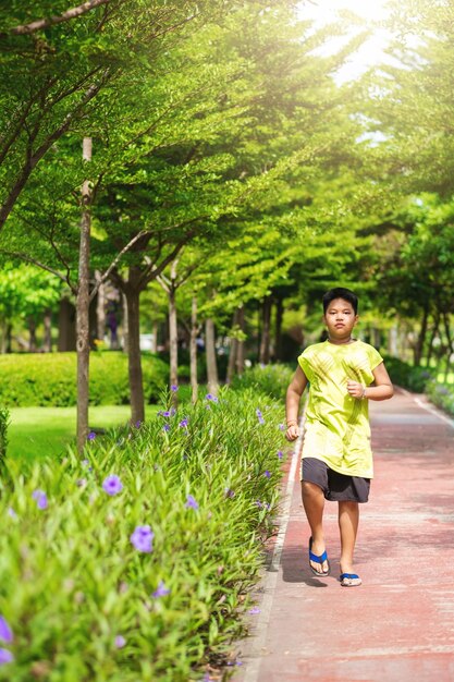 Asiatischer Mann, der am sonnigen Morgen im Park joggt