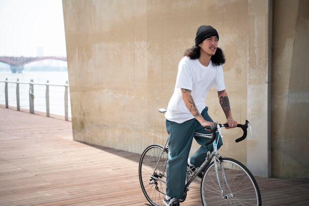 Asiatischer Mann, der sein Fahrrad fährt