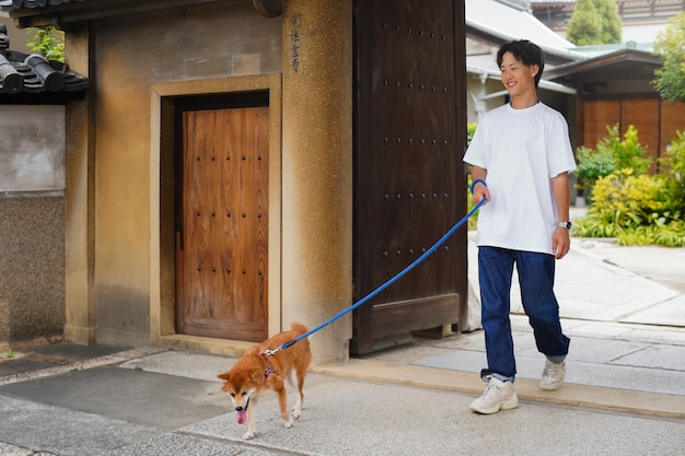 Kostenloses Foto asiatischer mann mit seinem shiba-inu-hund im freien
