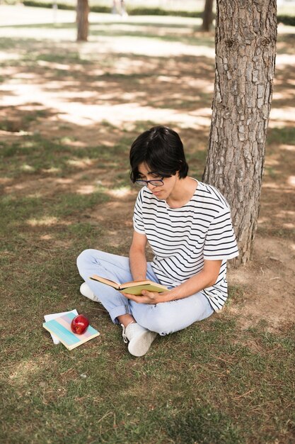 Asiatisches Jugendstudentenlesebuch unter Baum