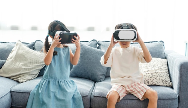 Asiatisches Kind, das sich aufgeregt fühlt, während es zu Hause ein 360 VR-Headset für Virtual Reality Metaverse verwendet
