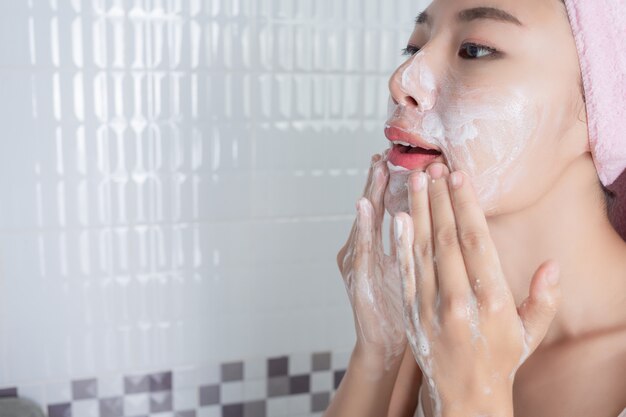 Asiatisches Mädchen wäscht Gesicht.