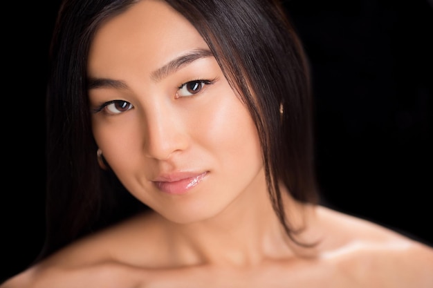 Asiatisches Schönheitsgesichtsnahaufnahmeporträt mit sauberer und frischer eleganter Dame. Studioaufnahme. Schwarzhaarige Dame, die für die Kamera lächelt.