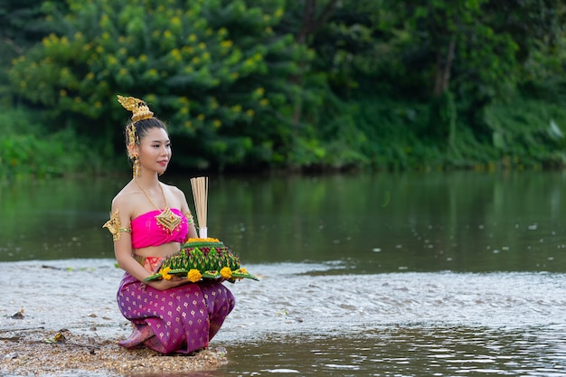 Kostenloses Foto asien frau in thailändischer kleidung traditionell halten kratong. loy krathong festival