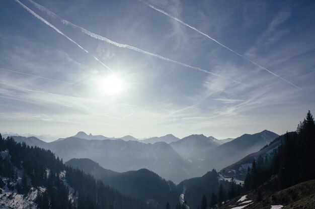 Atemberaubende Aufnahme einer Reihe von schönen Bergen unter einem hellen Himmel am frühen Morgen