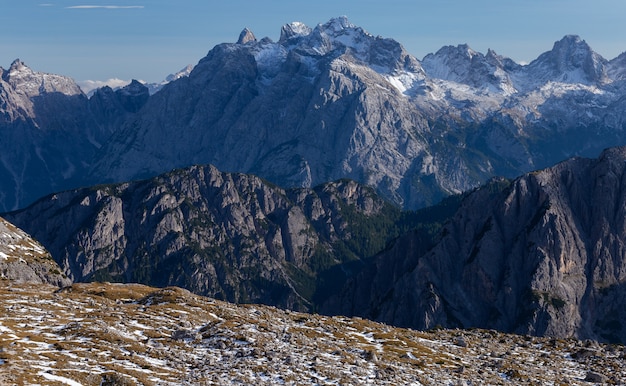 Atemberaubende Aufnahme von schneebedeckten Felsen in den italienischen Alpen unter dem hellen Himmel