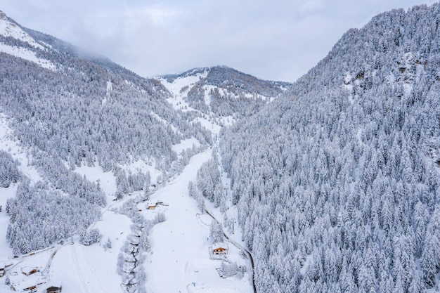 Atemberaubende Aussicht auf bewaldete Berge, die tagsüber mit Schnee bedeckt sind