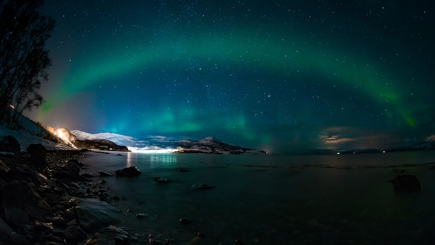 Atemberaubende Aussicht auf den See und die Berge unter dem faszinierenden Himmel mit einer Aurora