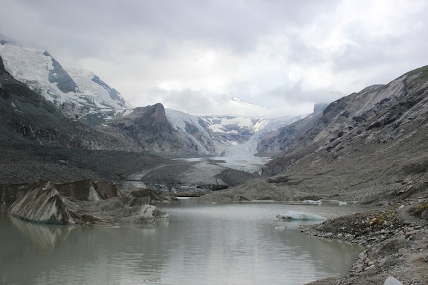 Atemberaubende aussicht auf einen see, umgeben von wunderschönen schneebedeckten bergen an einem nebligen tag surrounded