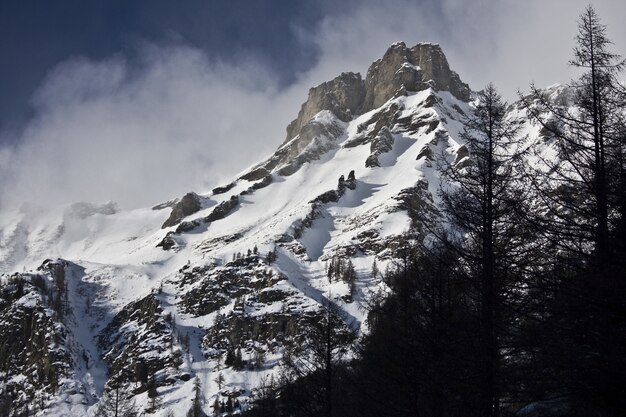 Atemberaubende Landschaft der schneebedeckten Berge unter einem malerischen bewölkten Himmel