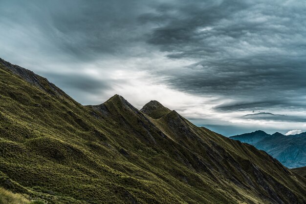 Atemberaubende Landschaft des historischen Roys Peak, der den düsteren Himmel in Neuseeland berührt