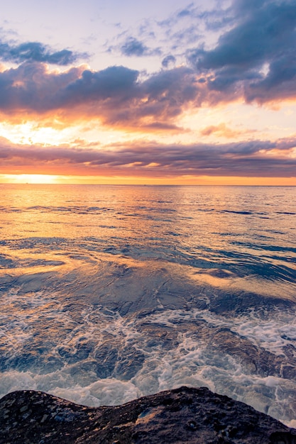 Atemberaubende Landschaft eines felsigen Strandes auf einem schönen Sonnenunterganghintergrund