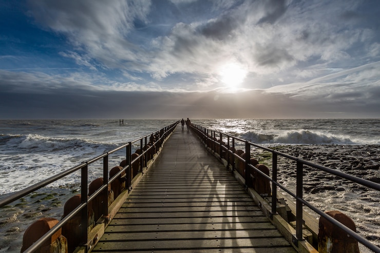 Kostenlose Foto atemberaubende landschaft eines sonnenaufgangs über dem pier des ozeans in westkapelle, zeeland, niederlande