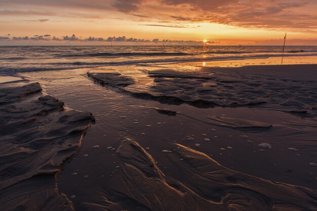 Atemberaubende Sonnenuntergangslandschaft über dem schaumigen Ozean