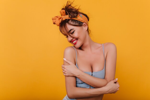 Atemberaubendes braunhaariges Mädchen im Retro-Outfit glücklich lächelnd