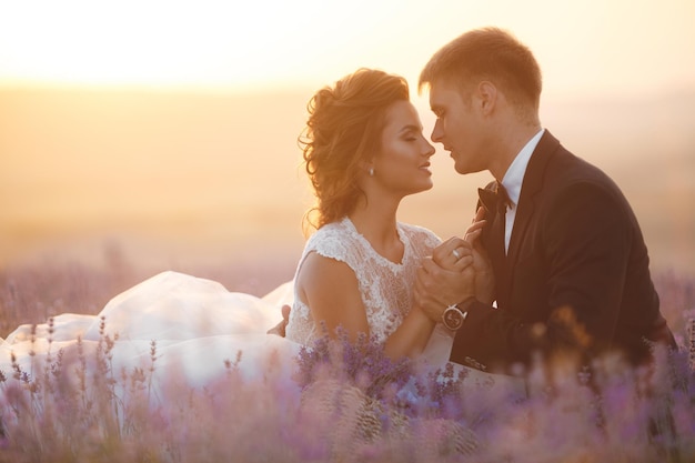 atemberaubendes Hochzeitspaar von Braut und Bräutigam bei Sonnenuntergang in Lavendel