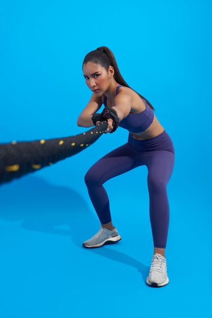 Kostenloses Foto athletin, asiatische sportlerin, die als teil einer fettverbrennungsübung in der fitness mit den seilen winkt