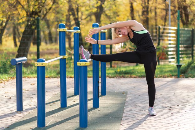 Athletische Blondine, die Übungen ausdehnend tun