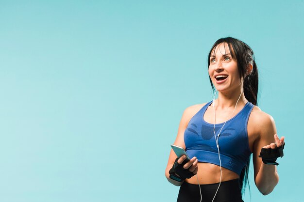 Athletische Frau des smiley, die Musik in den Kopfhörern genießt