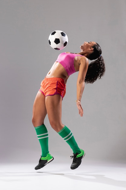 Athletische Frau, die mit Ball spielt
