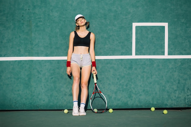 Athletische Frau in der Sportkleidung auf einem Tennisplatz