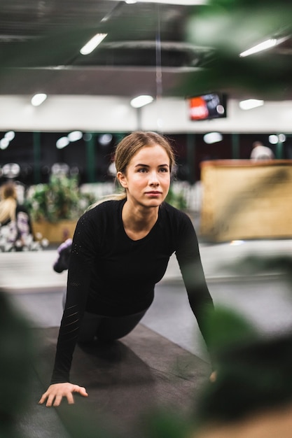 Athletische junge Frau, die Übung auf Yogamatte tut