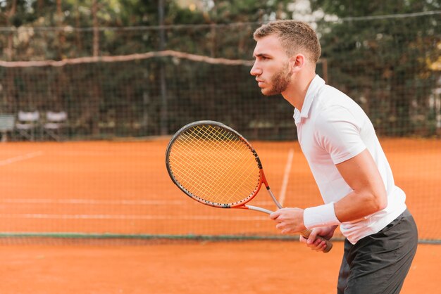 Athletischer Junge, der Tennis spielt