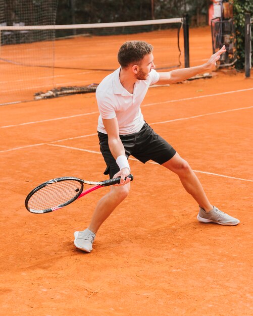 Athletischer Junge, der Tennis spielt