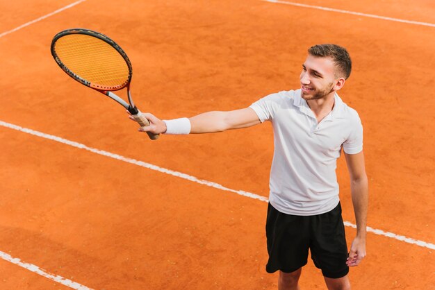 Athletischer Junge, der Tennis spielt