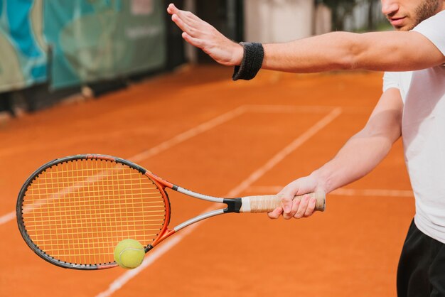 Athletischer Junge, der Tennis spielt