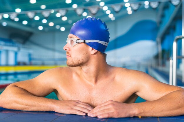 Athletischer männlicher Schwimmer, der weg schaut