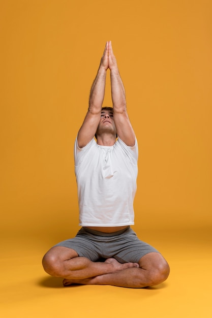 Athletischer Mann, der Yogahaltung tut