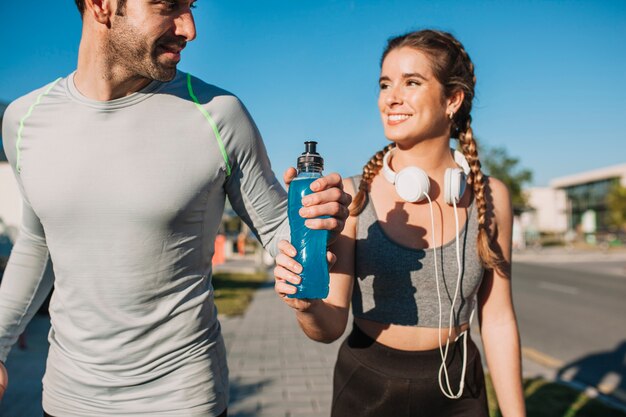 Athletischer Mann und Frau mit blauem Getränk