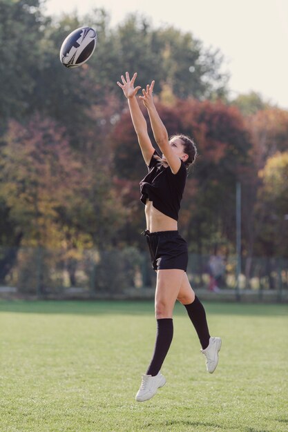 Athletisches Mädchen, das versucht, einen Rugbyball zu fangen