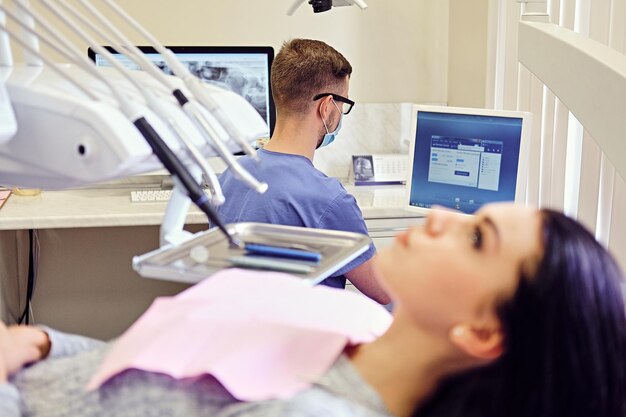 Attraktive brünette Frau auf einem Zahnarztstuhl in einem Stomatologieraum.
