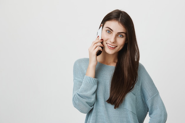 Attraktive dunkelhaarige Frau, die Telefongespräch führt