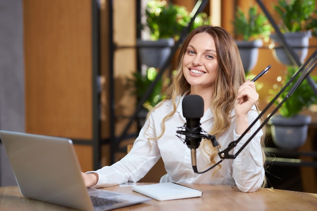 Attraktive Frau, die im Café sitzt und online spricht