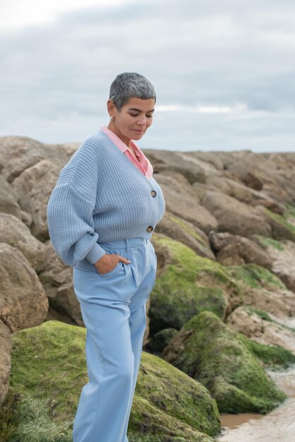 Attraktive Frau, die nahe Meer geht. Weibliches Model mit kurzen Haaren, die an bewölkten Tagen spazieren gehen. Natur, Freizeitkonzept